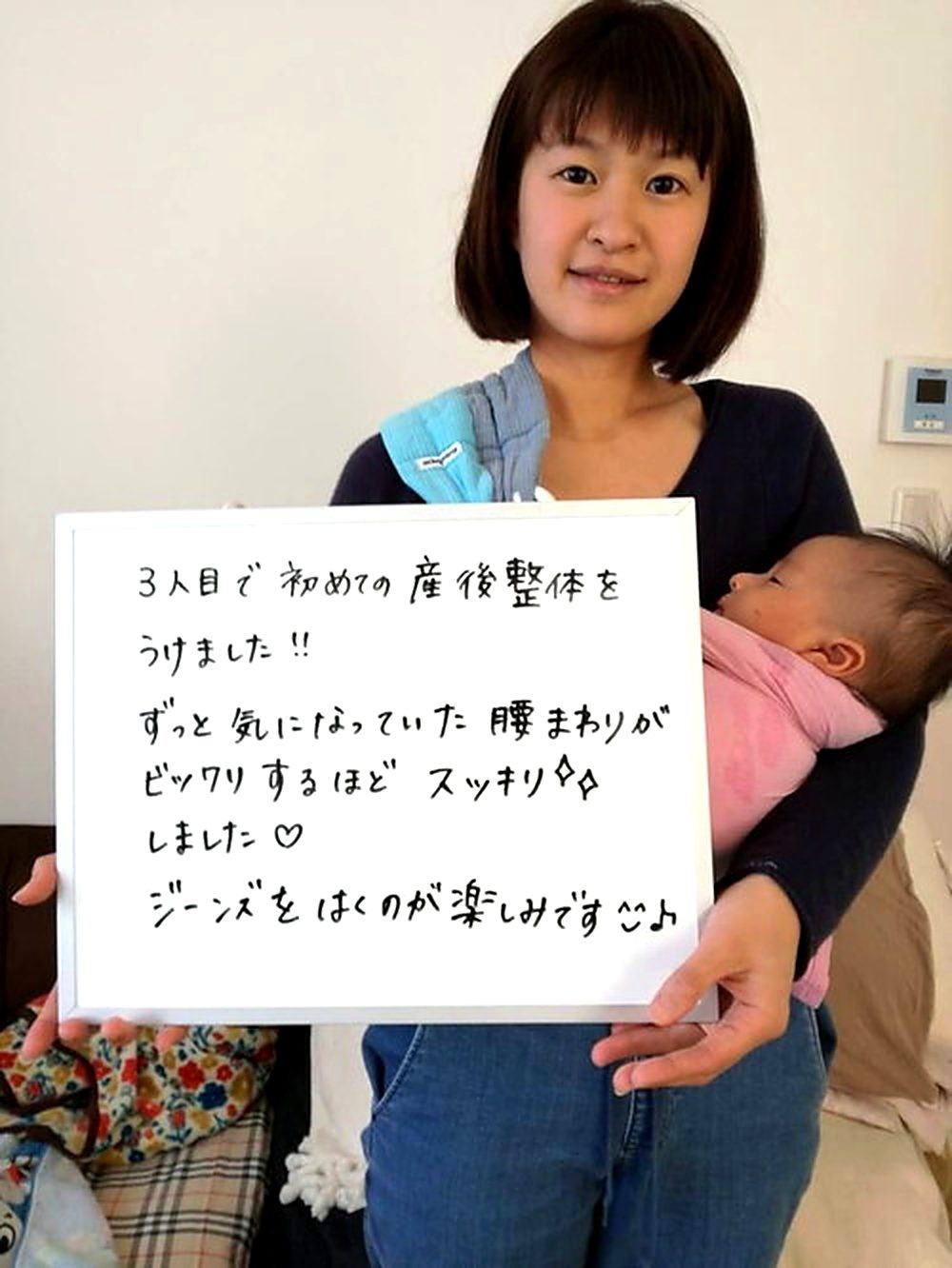 赤ちゃんと一緒のお客様のホワイトボード笑顔写真